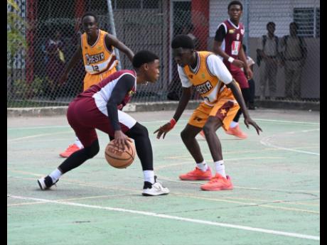 Herbert Morrison Technical High’s Antonio Kerr (left) tries to dribble around Manchester High’s Wasim Windett during Game 1 of the ISSA schoolboy Under-16 basketball finals at Herbert Morrison’s court on Monday, March 2.