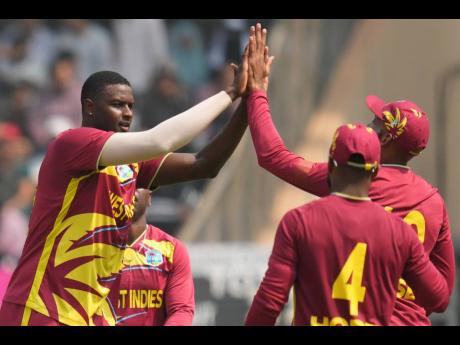 West Indies’ Jason Holder, (left), celebrates with teammate during the T20 World Cup cricket match against Nepal in Mumbai, India on February 15.