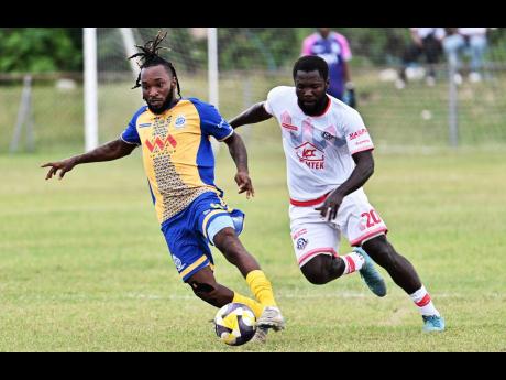 Kenly Deacon (left) of Harbour View dribbles the ball as he is chased by Portmore United’s Jahien Oshane Rose during the Jamaica Premier League football match at the Ferdi Neita Park on Sunday. Portmore United won 4-2.