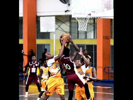 Andra Morgan of Manchester High School (left) stops Antonio Kerr of Herbert Morrison High from shooting during the ISSA rural basketball under-16 finals at G.C. Foster College of Physical Education and Sport in Angels, St Catherine, on Thursday.