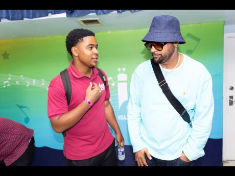 Jon-Christopher Wright (left), a student at the Alpha School of Music, interacts with international recording artiste Shaggy.