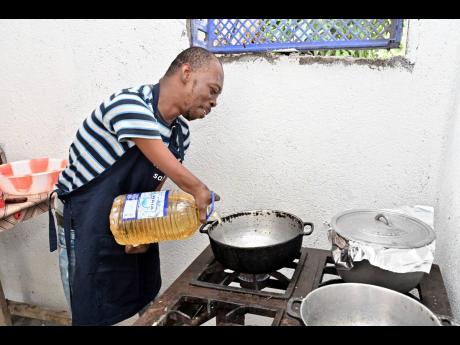Powell adds oil to his pot as he prepares fried chicken.