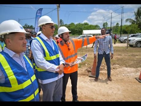 Prime Minister Dr Andrew Holness (centre), and Minister of Water, Environment and Climate Change,  Matthew Samuda (left), are briefed on works being carried out at the Rio Cobre Water Treatment Plant project site in Content, St Catherine, by Director of Water at VINCI Construction Grands Projets, Geoffrey Desportes, during a tour of the site.