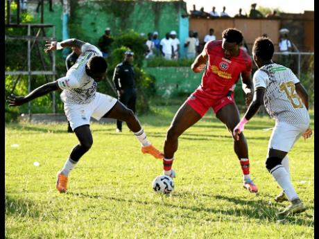 Montego Bay United’s Jahmari Clarke (centre) tries to escape Cavalier SC’s defenders Kwayne Thompson (left) and Dwayne Allen during their Jamaica Premier League football game at Jarrett Park in Montego Bay on Sunday. Montego Bay United won 3-1.