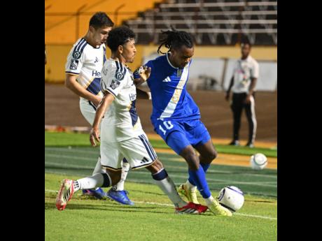 LA Galaxy's Mauricio Cuevas (centre) tackles Johnson Jeudy of Mount Pleasant during a Concacaf Champions Cup match at the National Stadium on Thursday, March 19, 2026.