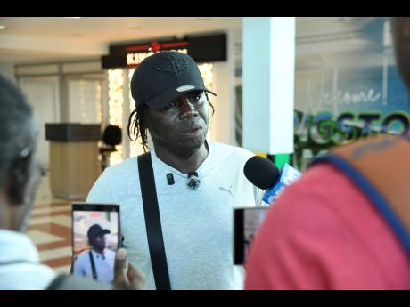 Garth Smythe, the coach of outstanding sprinter Shanoya Douglas, answers questions from the media shortly after Jamaica’s Carifta Games team arrived at the Norman Manley International Airport yesterday. 