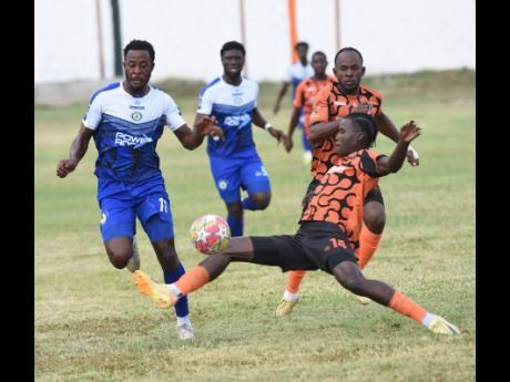 Jashaun Anglin (left), of Mount Pleasant Football Academy, evades a sliding tackle from Denville Watson of Tivoli Gardens FC during their rescheduled Jamaica Premier League football game at Edward Seaga Sports Complex on Wednesday, March 4. The game ended 1-1.
