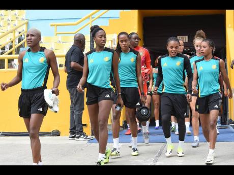 Members of the Reggae Girlz squad enter the National Stadium for a training session for their football game against Antigua & Barbuda on Friday.