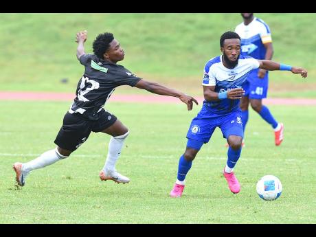 Credit: Ian Allen Demario Phillips (right) of Mount Pleasant FA dribbles past Kimarly Scott of Cavalier SC during their Jamaica Premier League football match at Stadium East on Thursday.