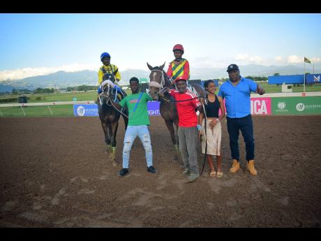 Credit: Anthony Minott BARNABY (right), with champion Jockey Raddesh Roman in the saddle and stablemate NERO STAR, with Jahvaniel Patterson aboard, parade with connections after BARNABY won the Lloyd Linbergh “Lindy” Delapenha Memorial Trophy, ahead of NERO STAR over a mile at Caymanas Park on Sunday, February 8.