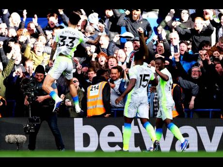 Manchester City’s Nico O’Reilly (left) celebrates after scoring during the English  Premier League soccer match against Chelsea in London, England, on Sunday.