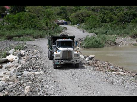 A truck navigates the alternative route through the Yallahs River after the closure of the Easington Bridge.