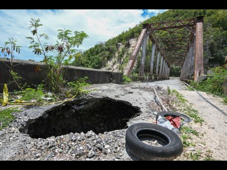 A gaping hole tears through the approach to the bridge in Easington, St Thomas.