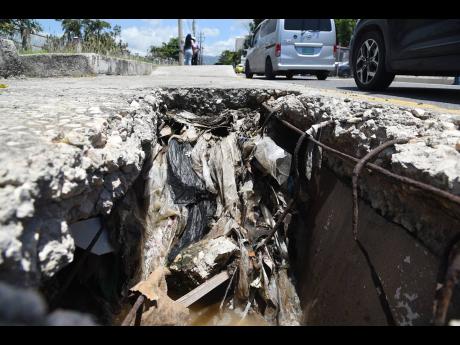 Pedestrians are being forced to navigate a gaping hole in the sidewalk along Marescaux Road in Kingston, directly across from the Ministry of Labour and Social Security.