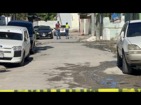 A police investigator and an investigator from the Independent Commission of Investigations (INDECOM) at the scene of a fatal police shooting in the Waltham area of St Andrew on April 15, 2026.