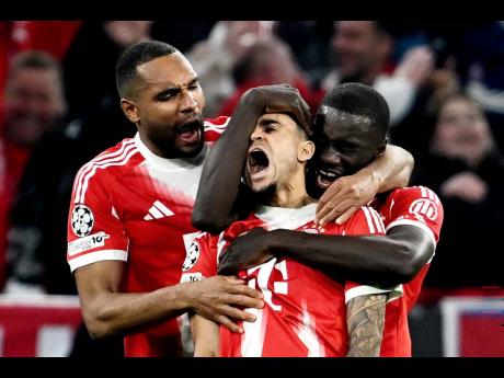 Bayern’s Luis Diaz (centre) celebrates with Dayot Upamecano (right) and Jonathan Tah after scoring their third goal during the Champions League quarterfinal second leg soccer match against Real Madrid in Munich, Germany, on Wednesday. Bayern won 4-3.