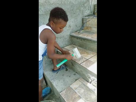 Young tiler Jelani Walker, 11, is learning the trade from his father Andrew.