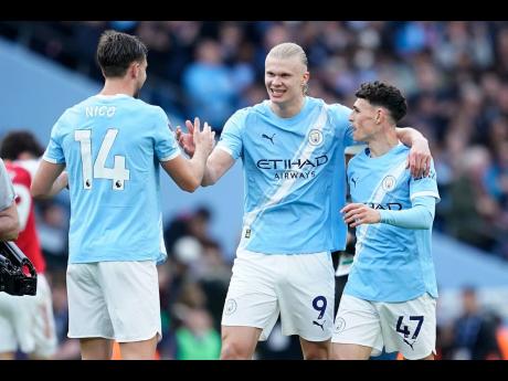 Manchester City’s Erling Haaland (centre) celebrates with his teammates Nico Gonzalez and Phil Foden at the end of the English Premier League match between Manchester City and and Arsenal, in Manchester, England, yesterday.