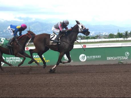 SLAM SHARP (right), ridden by Richie Shakes, wins the Aston Commock Memorial Trophy race at 20-1 ahead of LOCK DOWN, with Demar Williams aboard, at Caymanas Park yesterday.