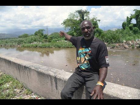 Christopher Irvin sits at the edge of Sandy Gully in St Andrew, where he has spent two decades risking his life in crocodile-infested waters to rescue victims and recover bodies. 