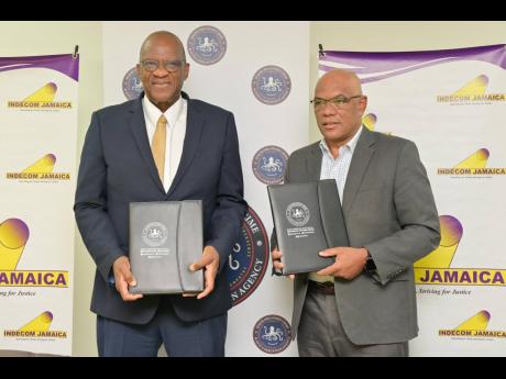 Independent Commission of Investigations Commissioner, Hugh Faulkner (left), and Director General at the Major Organised Crime and Anti-Corruption Agency (MOCA), Colonel Desmond Edwards, display signed copies of the Memorandum of Understanding (MOU) to formalise the agencies’ partnership. The MOU was signed during a ceremony at MOCA’s headquarters at NCB Towers in Kingston on Monday.