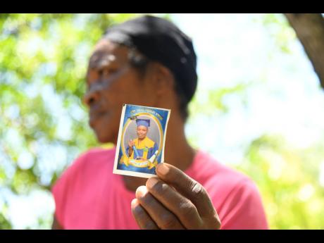 Peaches Sutherland, grandmother of Kland Doyle, who died on Monday following an altercation with his peers, holds a photo of him at their home in Castle Hill, Bath, St Thomas.