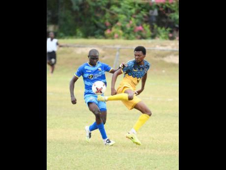 Tyrone Mullings of Racing United FC (right) kicks the ball while Michael Odupe of Molynes United FC (left) reacts during the Jamaica Premier League football fixture at Ferdi Neita Park in Portmore, St Catherine, on Wednesday.