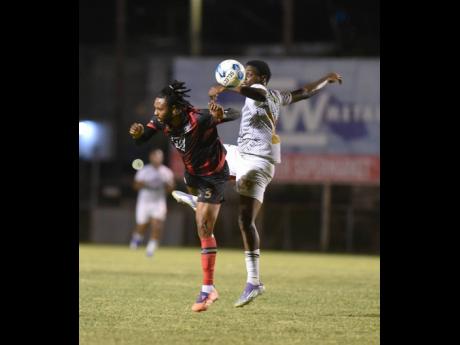Shane Watson (left) of Arnett Gardens F.C. and James Gallimore of Cavaliers S.C. compete for the ball during their Jamaica Premier League football match at the Anthony Spaulding Sports Complex on Thursday.