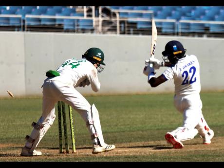 Barbados Pride’s right) Jonathan Drakes is stumped for 94 by wicketkeeper Romaine Morris of the Jamaica Scorpions on the opening day of their West Indies Championship cricket match at Sabina Park yesterday.