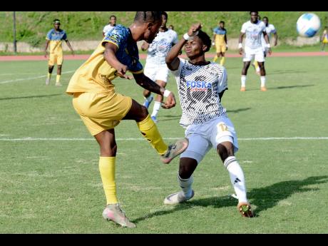 Mikyle Williams (left) of Racing United kicks the ball against Kimarly Scott of Cavalier SC during the Jamaica Premier League football match at Stadium East on Sunday.