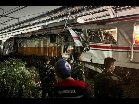 Indonesian soldiers examine the damage after a train crash at a station, in Bekasi, Indonesia, on Tuesday. 