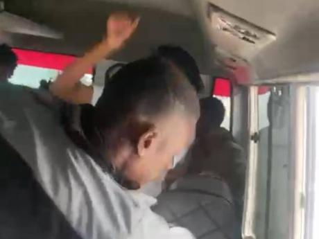 A screenshot from a video showing a bus conductor assaulting two Corporate Area schoolgirls.